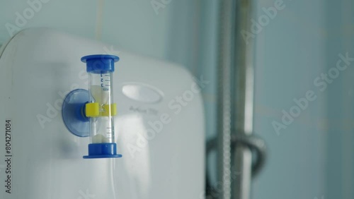 Miniature 3-minute sand hourglass in the bathroom in england uk. Saving water concept