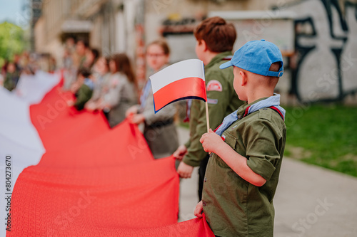 Flaga Polski trzymana przez harcerza