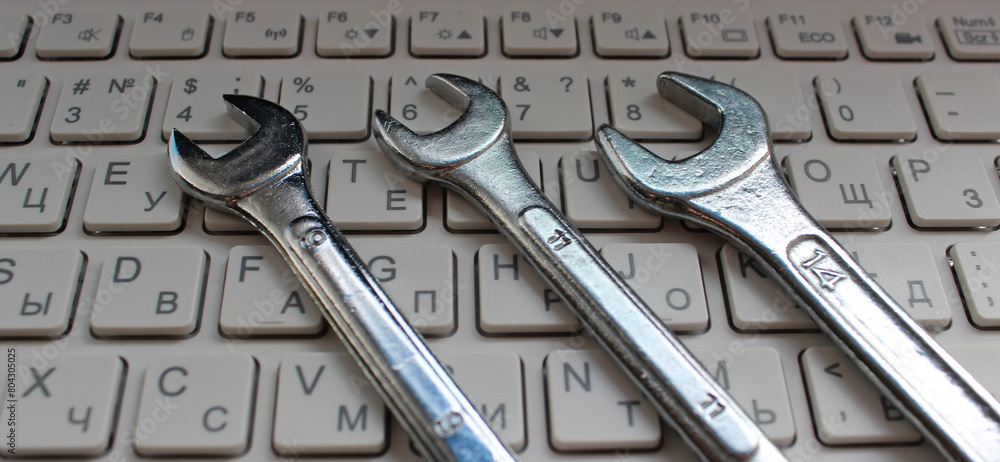 Fototapeta premium Computer Repairing Illustration. Hex Head Spanners On White Keys Of Laptop Keyboard 