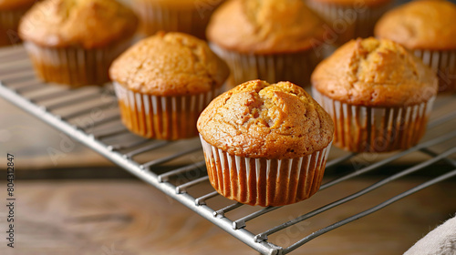 Cooling rack with tasty pumpkin muffins on table 