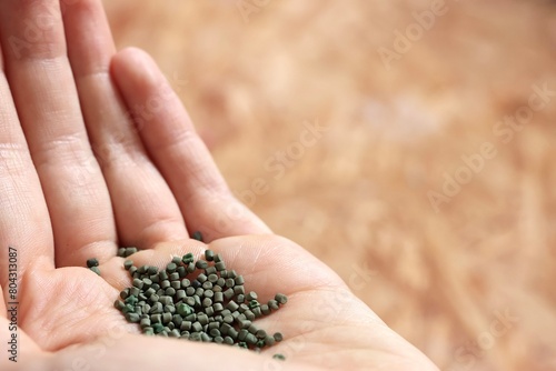 Hand of a Farmer throwing fertilizer on a field in a garden to grow plants efficiently symbolizing farming, gardening and agriculture