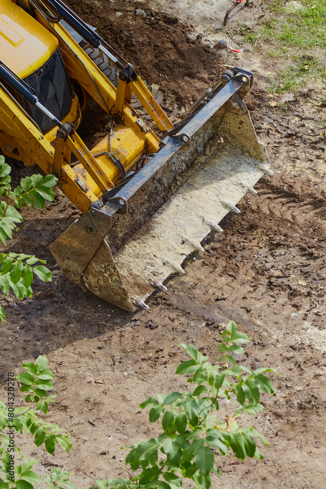 Fototapeta premium Bulldozer bucket on a dirt road, road construction, bulldozer work, close-up, vertical shot