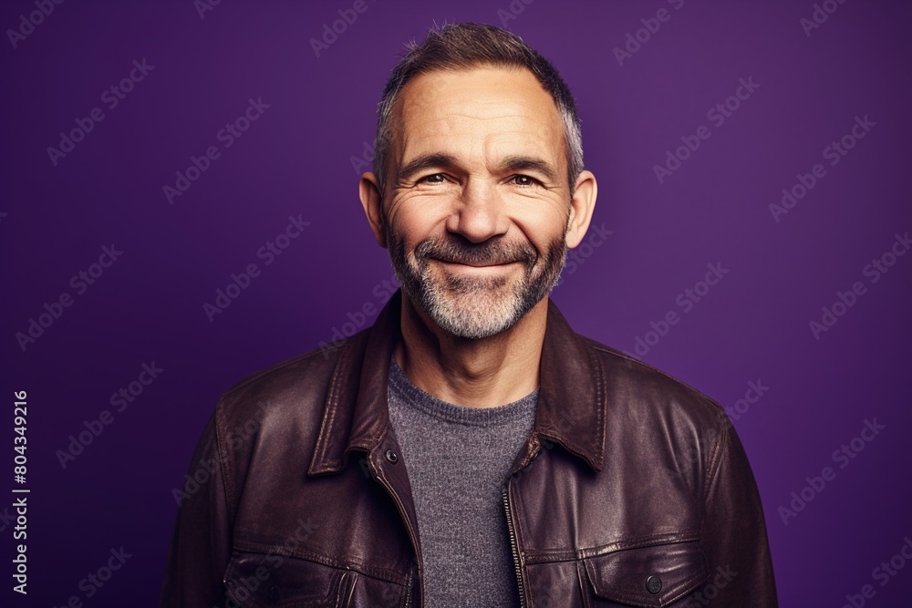 A man with a beard and gray hair is smiling at the camera