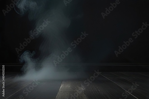 Empty dark background with smoke or fog hovering on the floor.