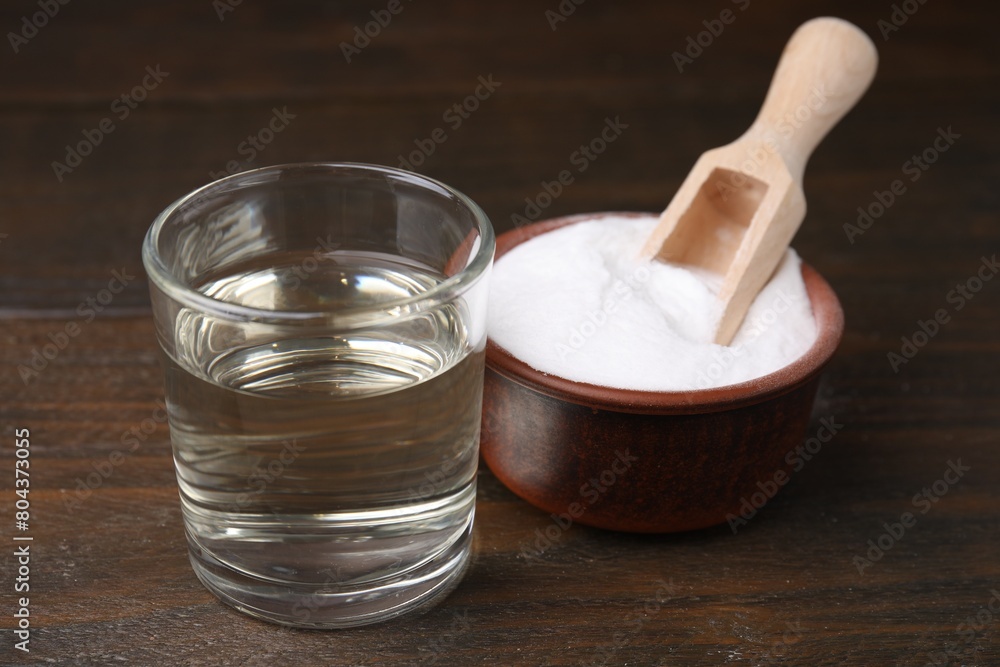 Vinegar in glass and baking soda on wooden table Vinegar in glass and baking soda on wooden table