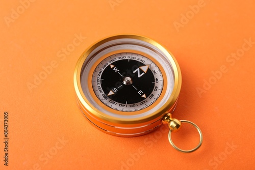 One compass on orange background. Navigation equipment