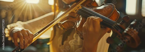 A violinist passionately playing her violin, lost in the moment, with the sun rays shining through the window. photo