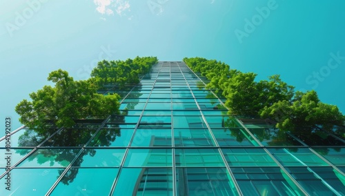 A high-rise building with green trees growing on the glass facade