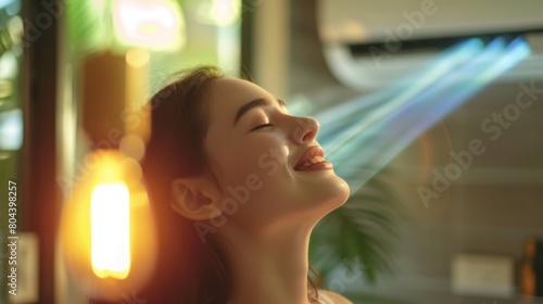 Face of a woman enjoying the soothing coolness of an air conditioner, blurred background of an air conditioned room