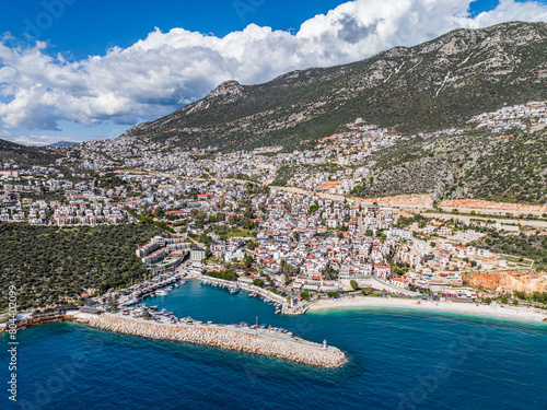 Fototapeta Naklejka Na Ścianę i Meble -  A stunning panoramic view of Kalkan, Kaş, in Antalya, Turkey, with beautiful hillside buildings and the tranquil Mediterranean Sea.