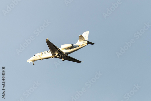 A private jet plane flying in a blue sky between clouds. Transportation. Air travel. Luxury.
