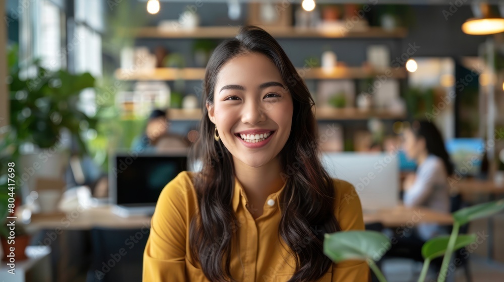 Asian female office worker smiling and talking to coworkers in an office online meeting. Asian female office worker smiling and talking to coworkers in an office online meeting.
