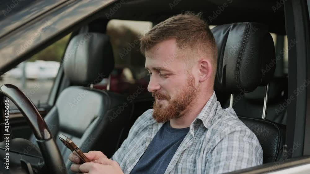 Male driver typing on the smartphone in the car. Slow motion Male driver typing on the smartphone in the car. Slow motion
