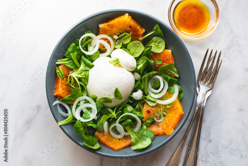 Burrata is a Pulian Italian cheese with a creamy base and a salad of red Sicilian oranges. Summer Italian cuisine, Puglia recipes, summer vitamims food. Summer lunch ideas, white  table