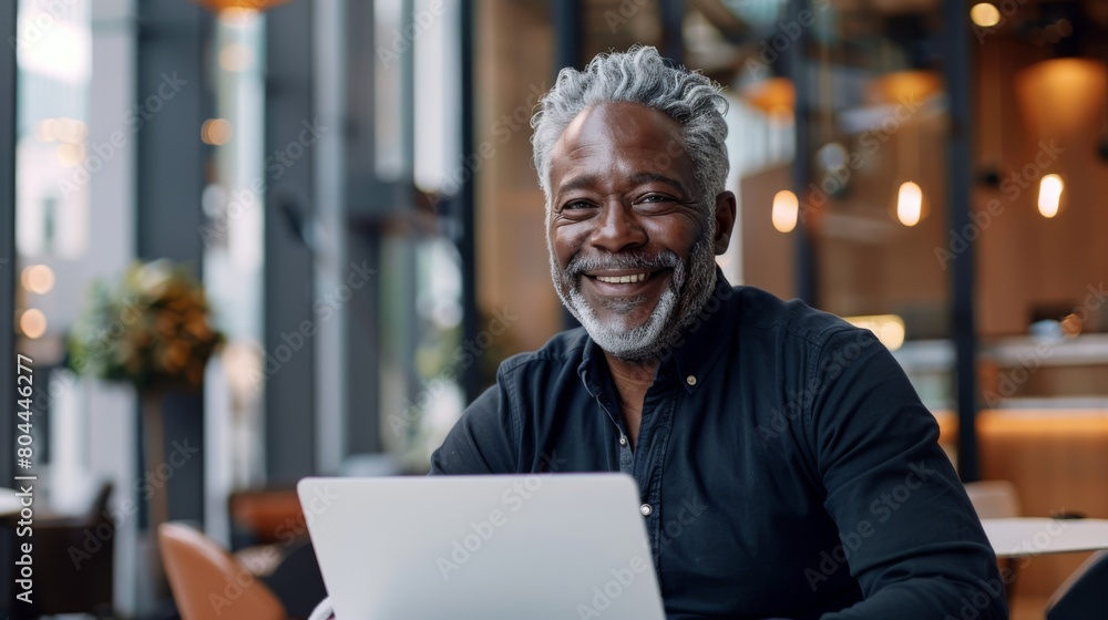 Senior Man with Laptop in Cafe