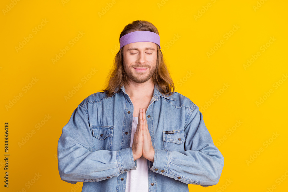Photo portrait of attractive young hippie man pray gesture closed eyes wear trendy denim outfit isolated on yellow color background Photo portrait of attractive young hippie man pray gesture closed eyes wear trendy denim outfit isolated on yellow color background