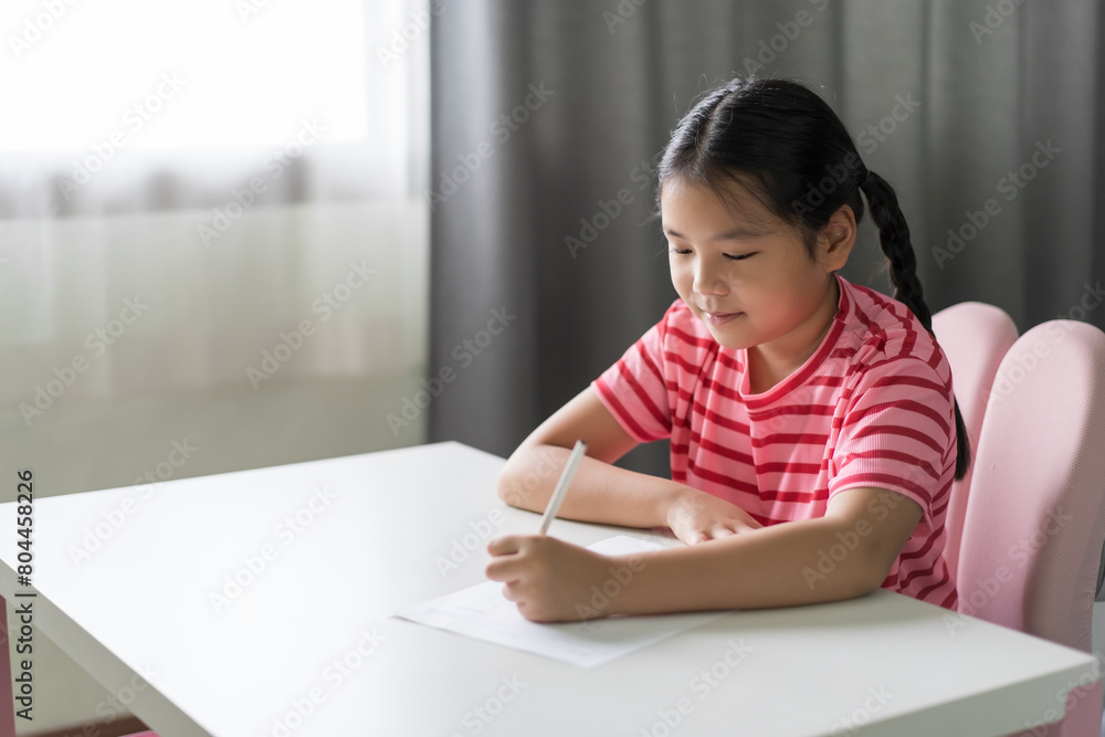 learn from home by asian child or kid girl student smile writing on paper to draw learning studying by left hand or young people fun doing homework in classroom homeschool on white table or desk learn from home by asian child or kid girl student smile writing on paper to draw learning studying by left hand or young people fun doing homework in classroom homeschool on white table or desk