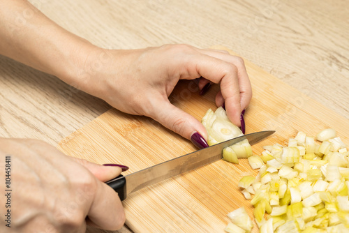 housewife cutting onions on a wooden board