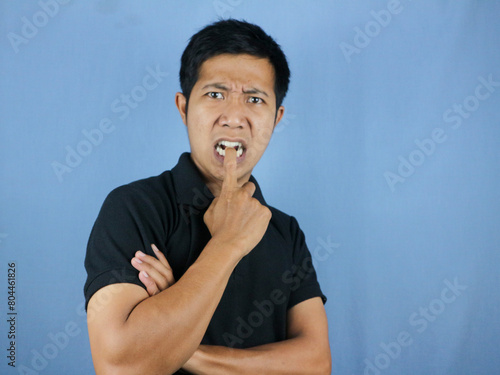 portrait of funny face expression of asian man surprised and biting finger. photo