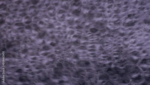 Foam droplets of water in slow motion. Rapid stream of moving bubbles. Fresh drink. Natural element of clean aquatic liquid.