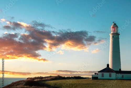 white lighthouse standing at coast of Wales the North Sea at sunrise, United Kingdom photo