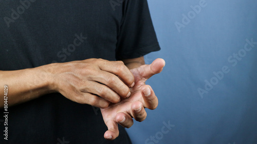 Asian young man scratching his hand isolated on blue background. photo