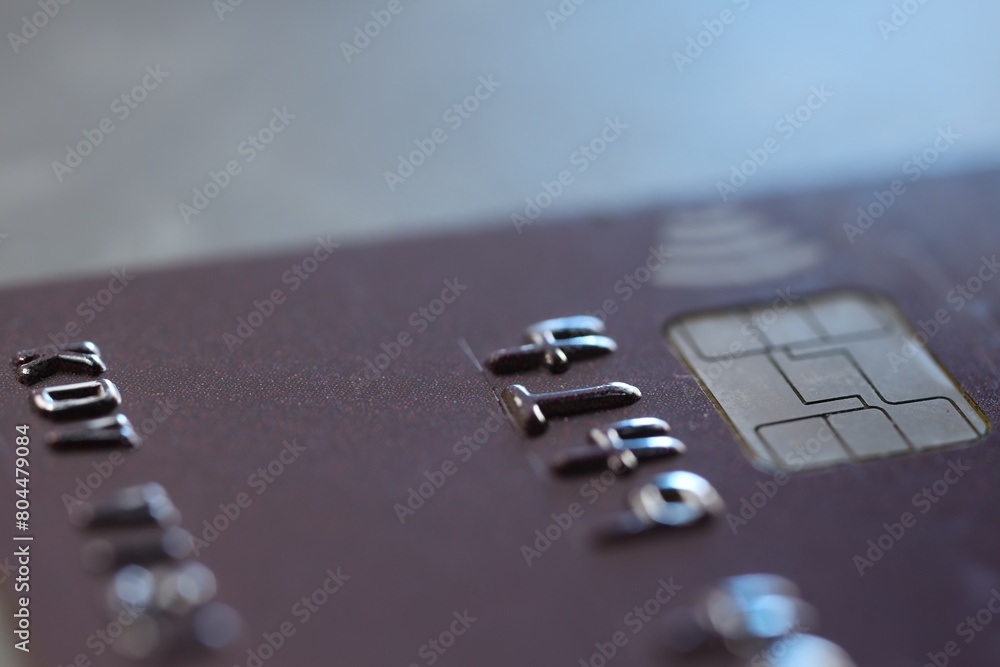 One credit card on gray background, macro view One credit card on gray background, macro view