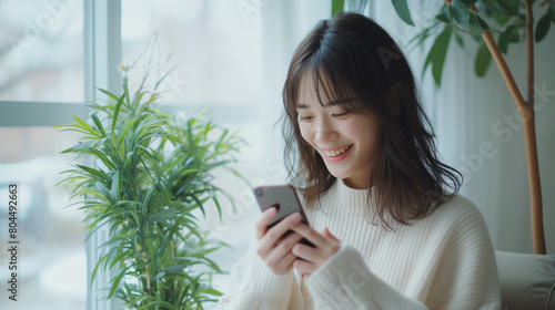 笑顔でスマホを操作する女性