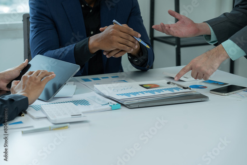 Fototapeta Naklejka Na Ścianę i Meble -  Two businessmen are shaking hands in office while sitting at the desk, Business people concept