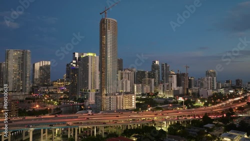 Aerial view of cars driving on Downtown I95 Riverside multilane highway at night with Miami skyline view. Drone flight over rush hour traffic on the highroad in Miami photo