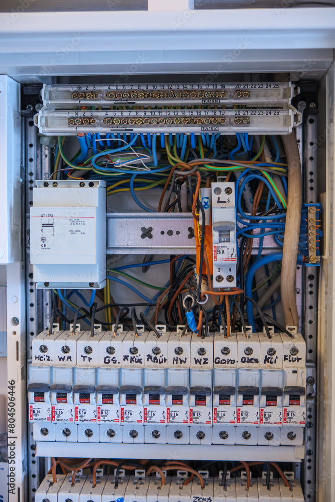 An electrician works on a fuse box