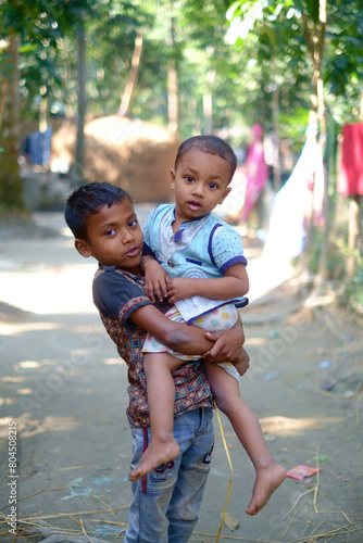 Portrait of Bangladeshi rural boys, elder brother is holding his younger brother in his arms 