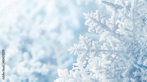   A tight shot of snowflakes against a blue and white backdrop, softly blurring additional snowflakes © Jevjenijs