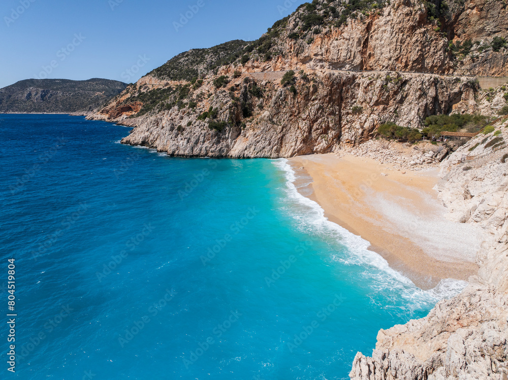 A serene view of Kaputaş Beach in Kalkan, Turkey, with vibrant turquoise waters and golden sand along the Mediterranean coast. A serene view of Kaputaş Beach in Kalkan, Turkey, with vibrant turquoise waters and golden sand along the Mediterranean coast.