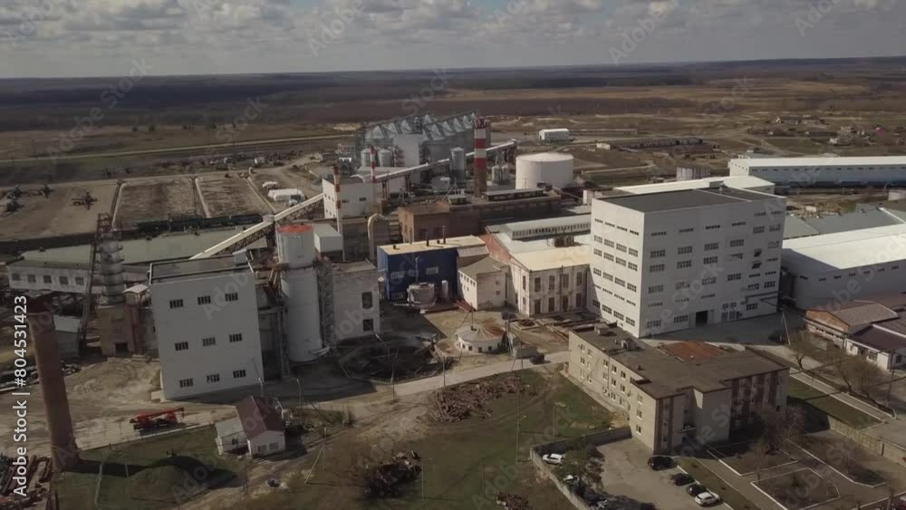 An aerial view of a factory surrounded by fields under a cloudy sky An aerial view of a factory surrounded by fields under a cloudy sky