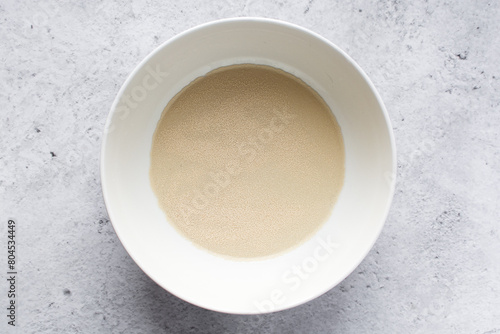 Instant dry yeast sprinkled on warm water, dry yeast granules on water