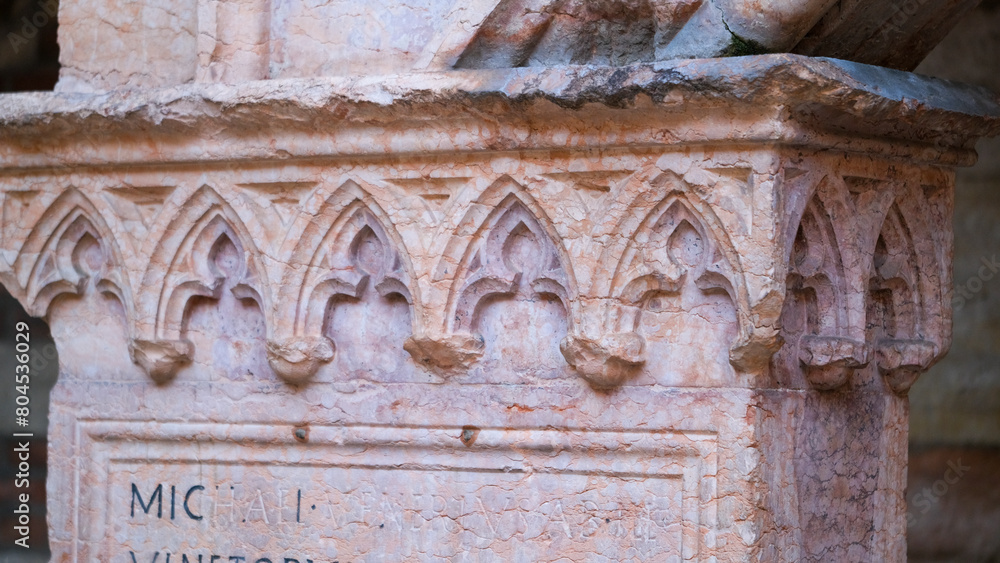 Sculpture atop stone column in ancient building facade