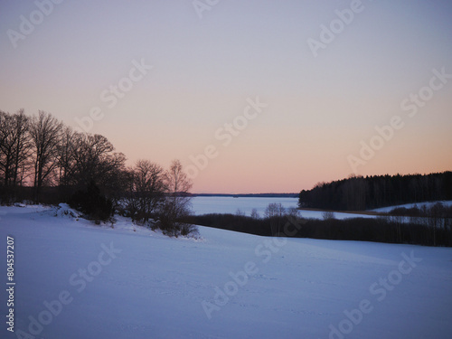 Scenic view of a field and lake against sky during sunset