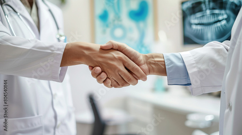 "Two doctors shaking hands in a medical office, professional greeting in a healthcare setting, collaboration and teamwork among medical staff, clean and well-equipped clinic background