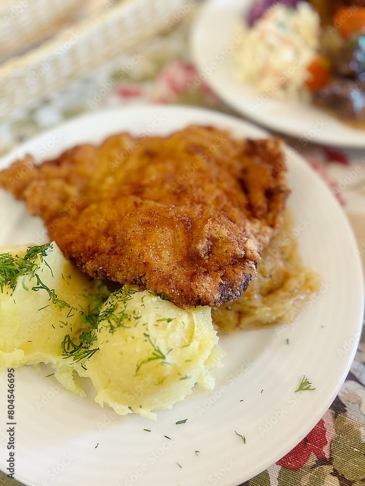 large pork chop, breading on the cutlet, mashed potatoes, lunch dish, typical Polish dinner, potato pancakes with goulash, salads, dinner in a restaurant large pork chop, breading on the cutlet, mashed potatoes, lunch dish, typical Polish dinner, potato pancakes with goulash, salads, dinner in a restaurant