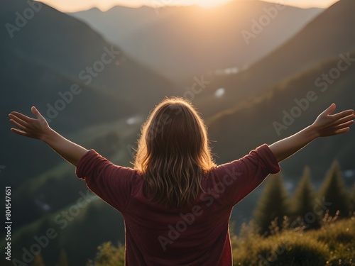 Young woman with arms outstretched enjoying the view of the mountains