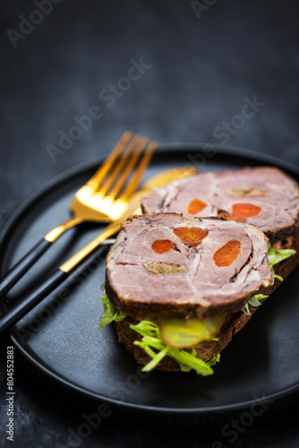 Gourmet sandwich with roasted pork (ham), pickled cucumber, lettuce, sauce, artisan bread