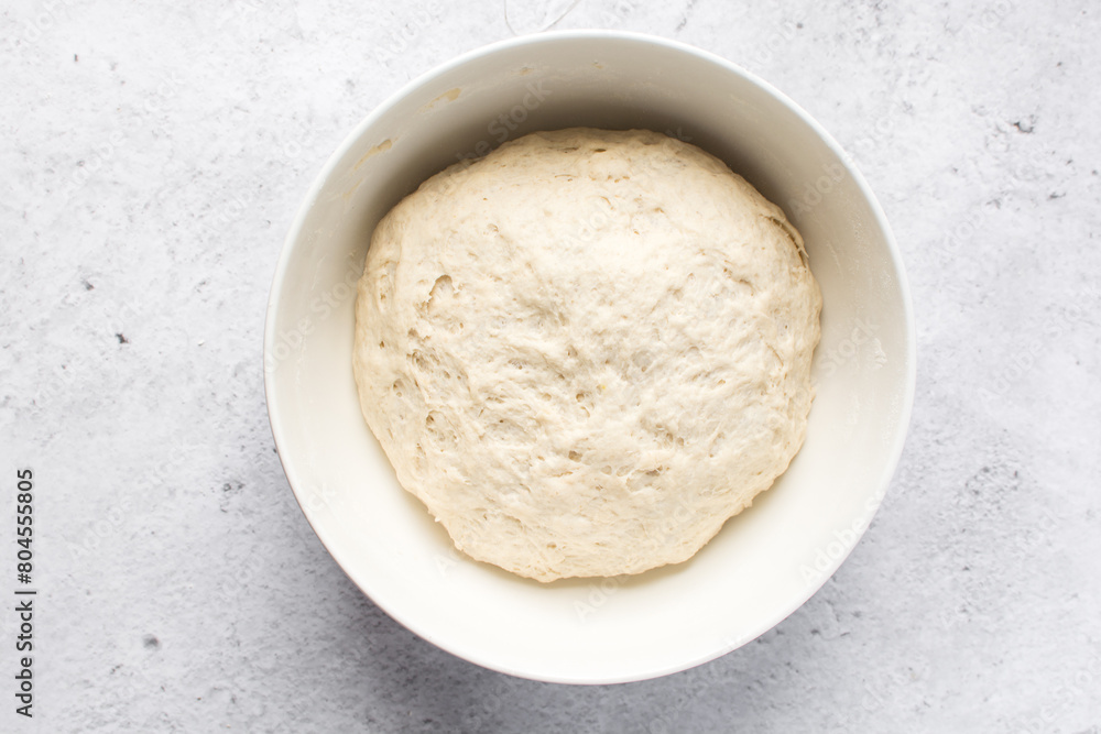 Bread dough that has doubled in size, dough that has risen, proofed dough in a white bowl Bread dough that has doubled in size, dough that has risen, proofed dough in a white bowl