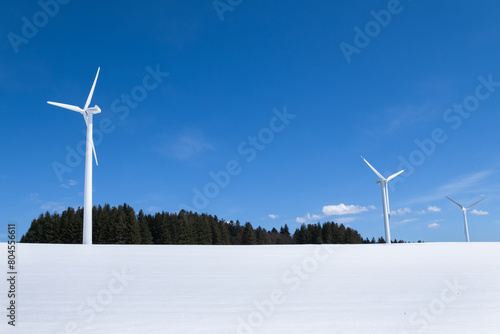 three wind turbines in snow surroundings are on the mountain