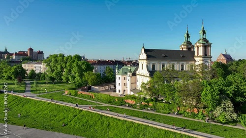Krakow, Poland. Skalka, St. Stanislaus Baroque church na Skałce and Paulinite monastery. Aerial panning video in spring. People walking on boulevard and promenade. Old town and Wawel in the background photo