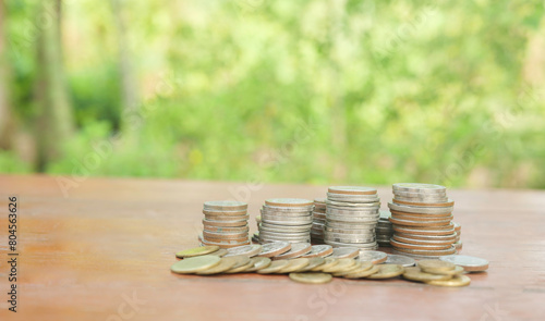 Close up of  stacking coins on wooden table with green bokeh background, Business Finance and Money concept, Save money for prepare in the future.