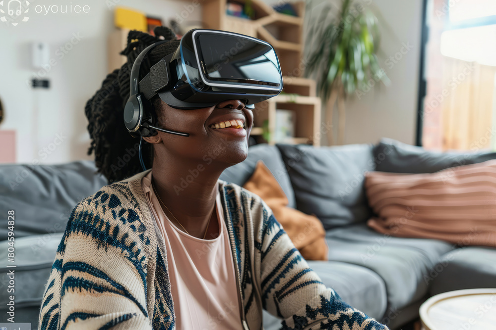 A woman of African descent, sporting a headset, smiles as she interacts with a tablet in her living room, indicating her enjoyment and ease with modern technology. A woman of African descent, sporting a headset, smiles as she interacts with a tablet in her living room, indicating her enjoyment and ease with modern technology.
