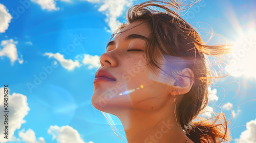 Young woman on the background of the blue sky with clouds.