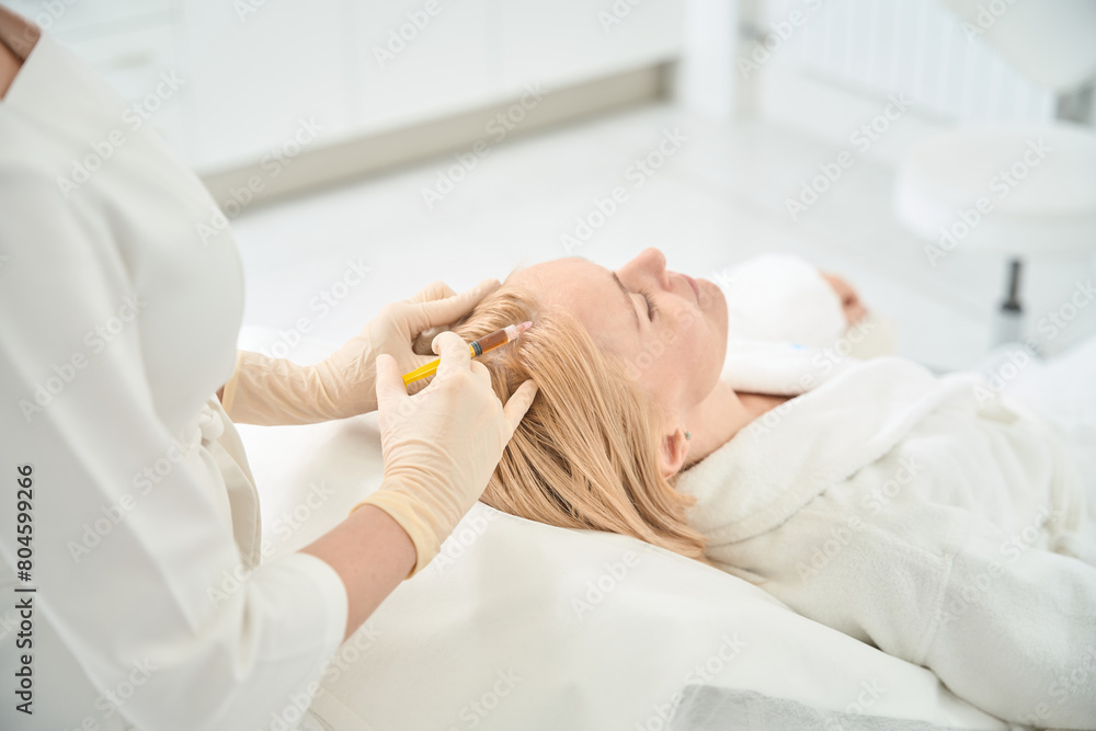 Dermatocosmetologist making hair plasmolifting procedure to female client Dermatocosmetologist making hair plasmolifting procedure to female client