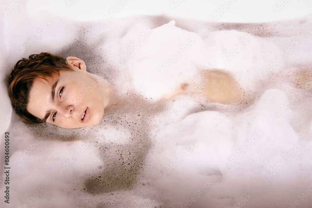 A young attractive man is washing himself in the bathroom. A young attractive man is washing himself in the bathroom.